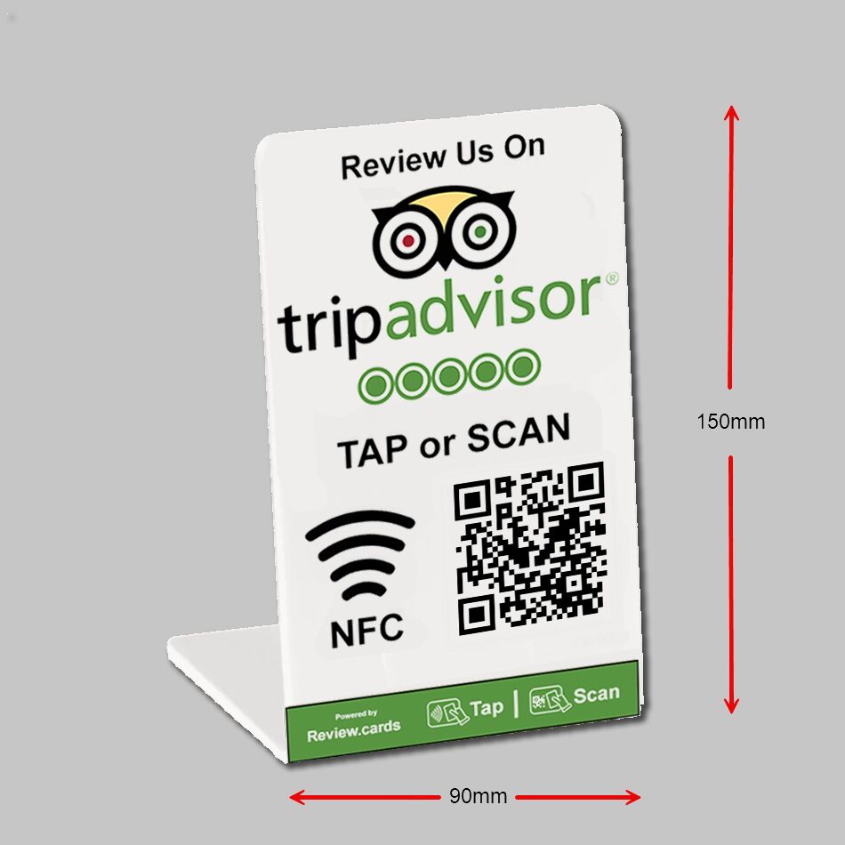 A small, white, L-shaped stand on a grey background displaying the TripAdvisor logo at the top. Below are five green circles representing ratings and text that reads "TAP or SCAN." This TripAdvisor Tap or Scan PoP Stands - FREE Delivery features an NFC symbol and a QR code. Red arrows indicate dimensions: 150mm in height and 90mm in width.