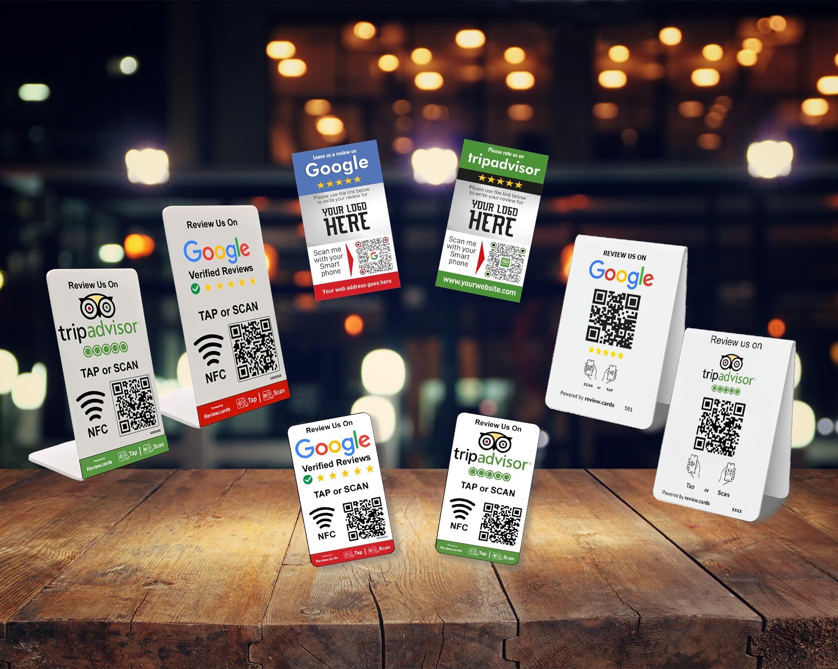 A collection of Hospitality Bundle 1 from TripAdvisor, featuring QR codes and NFC tags for reviews. The cards are displayed on a wooden surface with a blurred background of warm lights, creating a cozy ambiance.