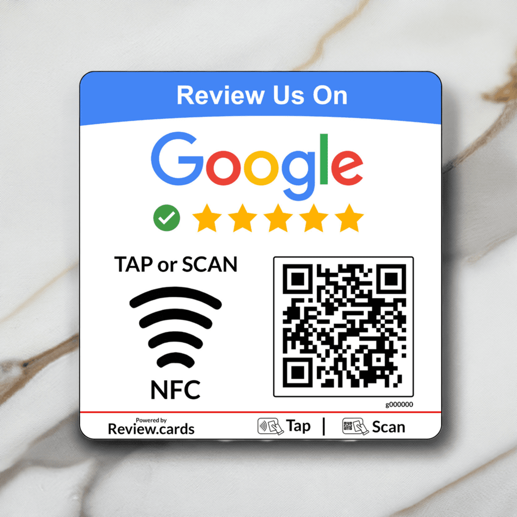 A square Google NFC Review Plate instructs users to review a business on Google. It features the Google logo, five stars, a check mark, "TAP or SCAN" text, an NFC icon, and a QR code. The plate is placed on a white marble surface with "Review.cards" attribution at the bottom.